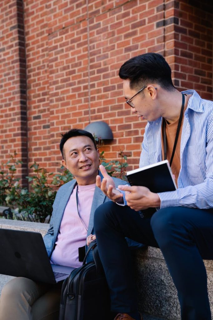 Two men in business attire having a collaborative discussion outdoors.